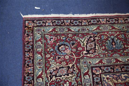 A Persian red and blue ground carpet. 9ft 10in by 7ft 2in.